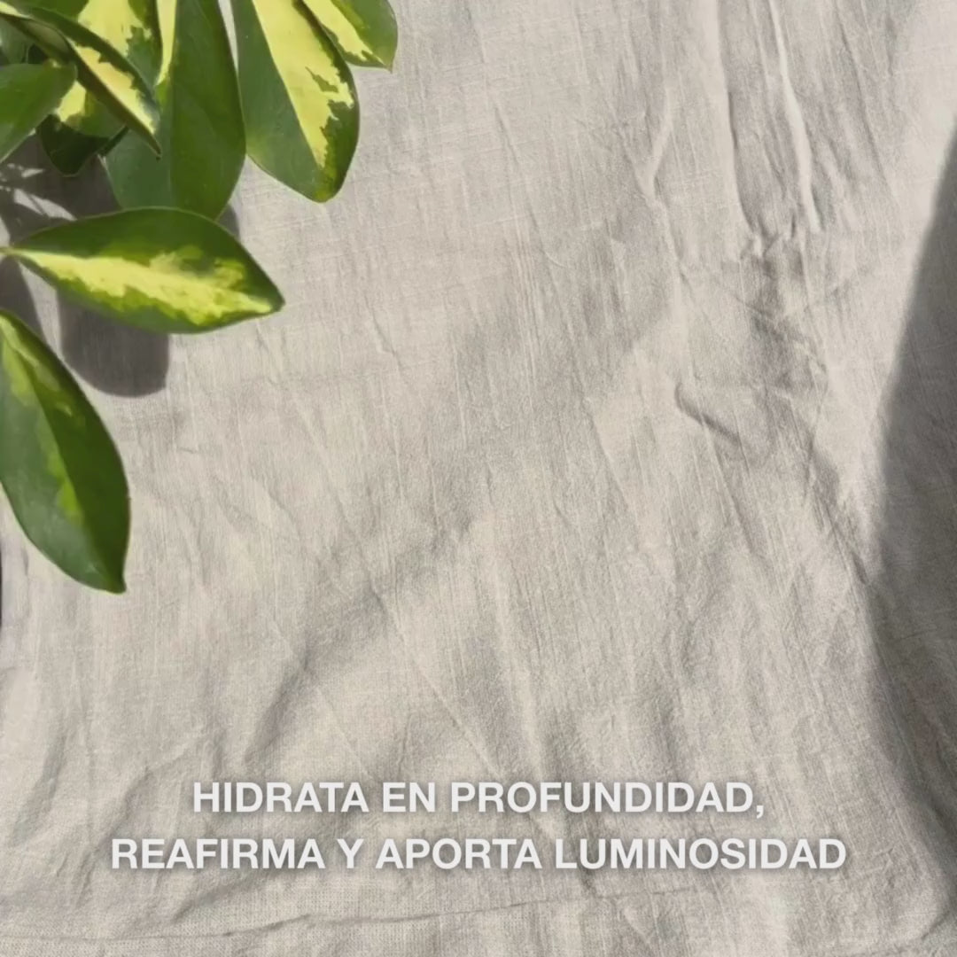 Primer plano de una mujer aplicando una máscara facial de colágeno y vitamina B12 de color rosa intenso sobre la piel limpia: la extiende sobre mejillas, frente y barbilla, mientras el colágeno y la B12 hidratan, reafirman, calman y aportan un brillo radiante.