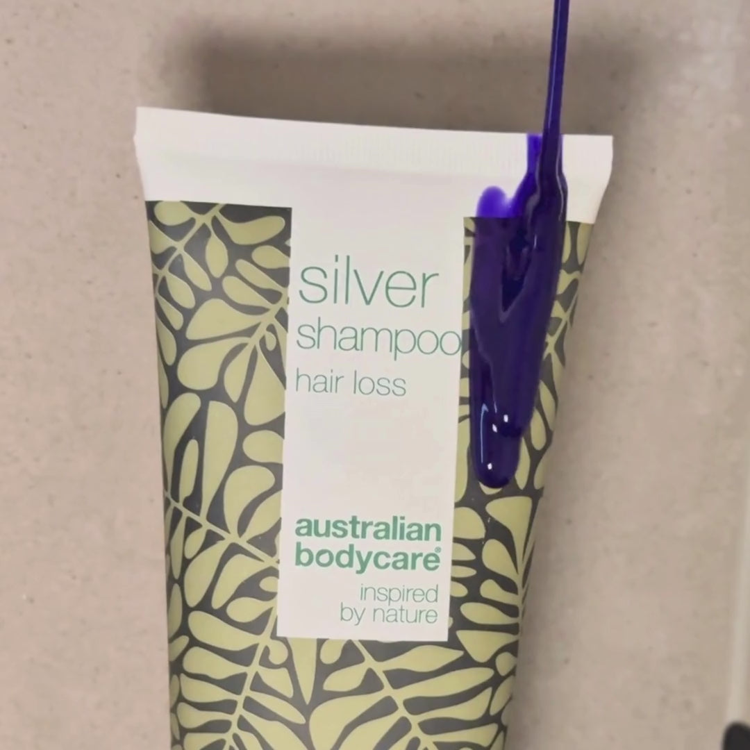 Vídeo que muestra nuestro champú Hair Loss Silver con un tono plateado-violeta aplicado sobre el cabello mojado en la ducha.