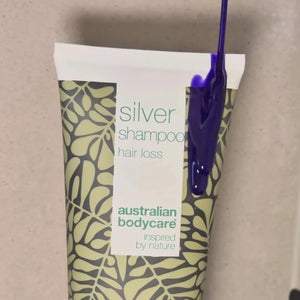 Vídeo que muestra nuestro champú Hair Loss Silver con un tono plateado-violeta aplicado sobre el cabello mojado en la ducha.