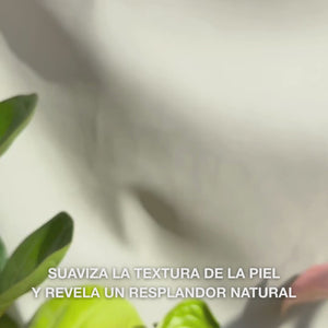 Primer plano de una mano que dispensa unas finas gotas de sérum peeling translúcido y ligero sobre las yemas de los dedos, masajeándolas suavemente sobre la piel limpia del rostro — su textura sedosa y fluida disuelve visiblemente células muertas, refina la textura cutánea y realza el brillo gracias a AHAs naturales (Lime Pearl), niacinamida y aceite de árbol de té 